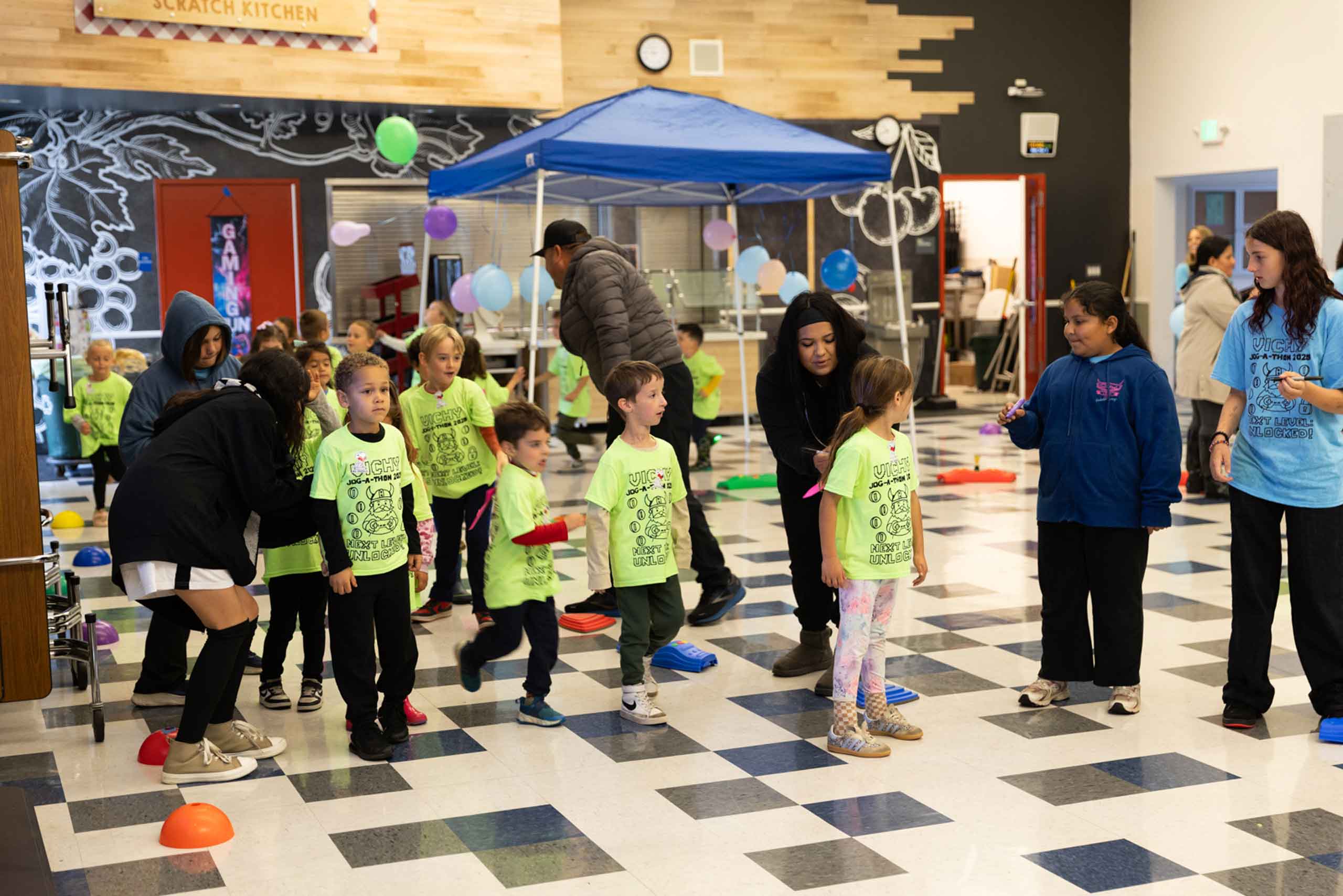 Vichy students in neon green shirts in the cafeteria for the jog-a-thon